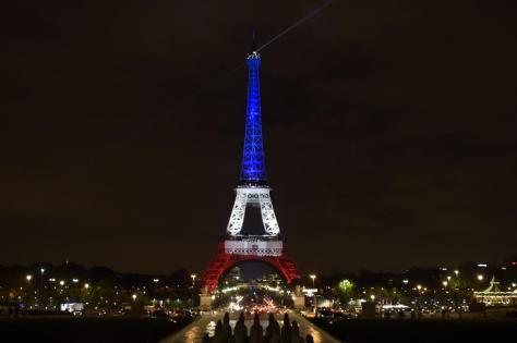 A photo taken on November 16, 2015 in Paris shows the Eiffel Tower illuminated with the colors of the French flag in tribute to the victims of the November 13, 2015 Paris terror attacks. AFP PHOTO / ALAIN JOCARD        (Photo credit should read ALAIN JOCARD/AFP/Getty Images)